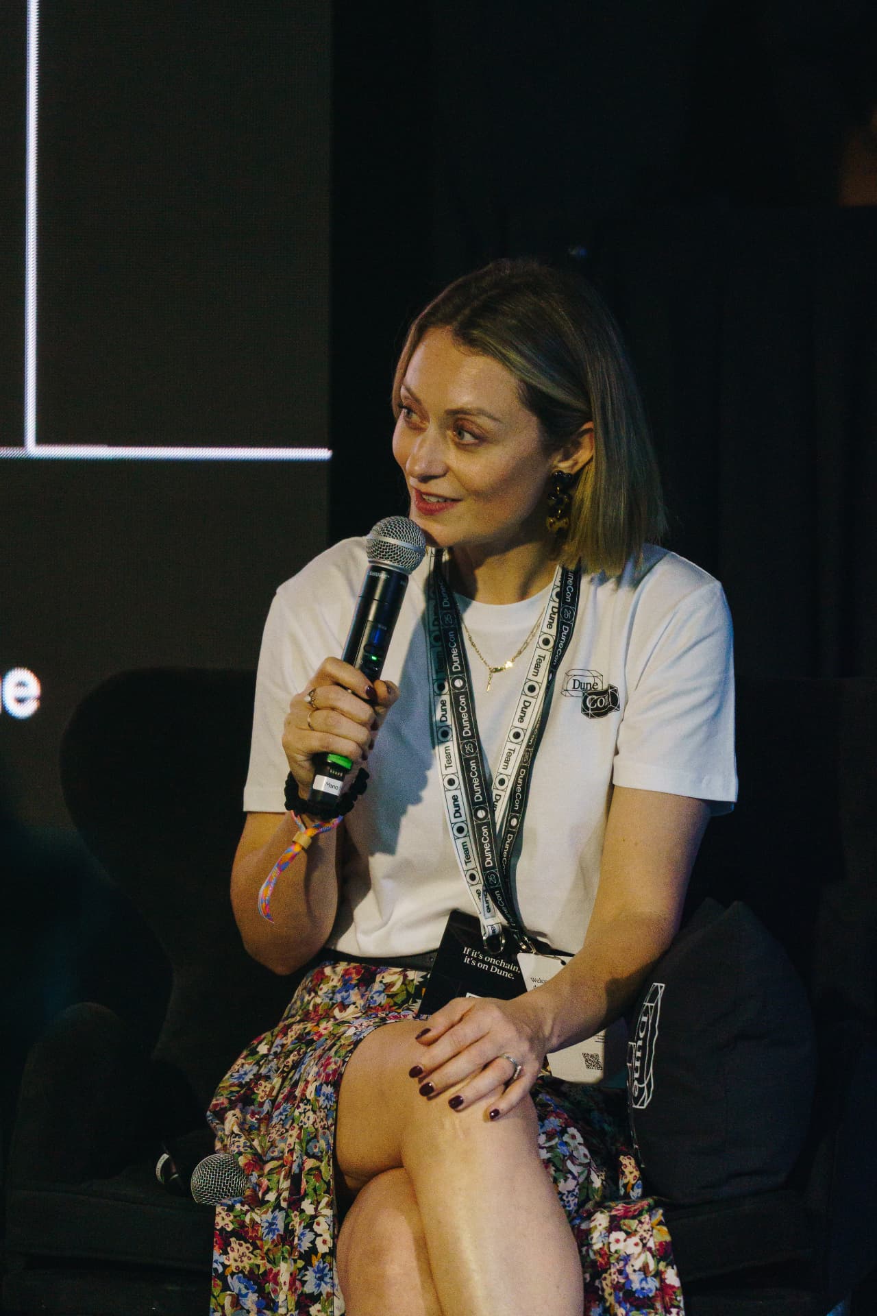 Beccy Ingram speaking with a microphone on stage at a company conference